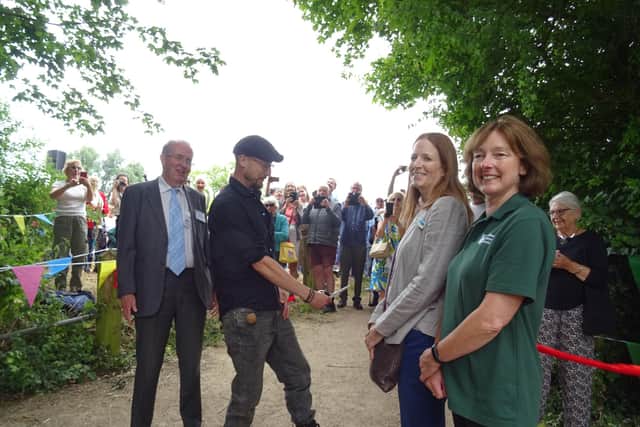 Robbie Cumming cutting the ribbon at the towpath, WCT Chairman to his left and Ros Daniels, Canal & River Trust, and Dr Elaine King, Chiltern National Landscape, to his right.