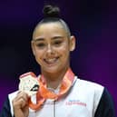 Jessica Gadirova celebrates on the podium with her gold medal after winning the Women's Floor Exercise final at the World Gymnastics Championships in Liverpool. Photo: Getty.