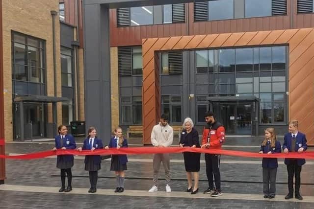 Councillor Anita Cranmer cuts the ribbon with special guests; boxers Adam and Hassan Azim and members of the school council.