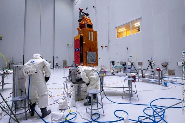 Two of the European Astrotech team work on fuelling the Biomass climate satellite in a clean room at Kourou, French Guiana
