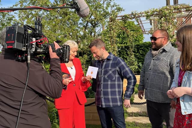 TV presenter Nikki Chapman hands garden designer James Smith the gold medal in the London Square Community Garden