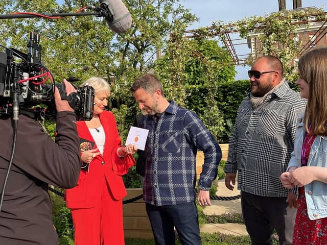 TV presenter Nikki Chapman hands garden designer James Smith the gold medal in the London Square Community Garden