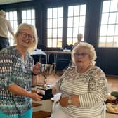 Sally McAvoy (sat down) receiving the  the Colin Carter Cup for most points overall from Ann Sear