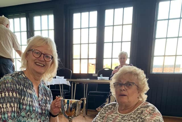 Sally McAvoy (sat down) receiving the the Colin Carter Cup for most points overall from Ann Sear