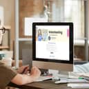 Volunteer looking at Volunteer Bucks platform on computer screen