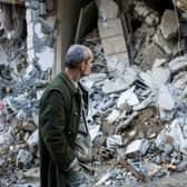 A man walks past a collapsed building in the town of Jbaleh in Syria's northwestern province of Latakia following the earthquake.