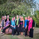 The Adstock Singers, including Emma Shudell, seated with a blue scarf, who passed away last September