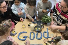 Children and nursery practitioners spelling the word 'Good'.