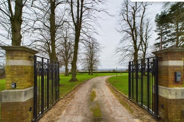 The electric double gated entrance, this picture also shows the vast countryside surroundings new owners could enjoy.