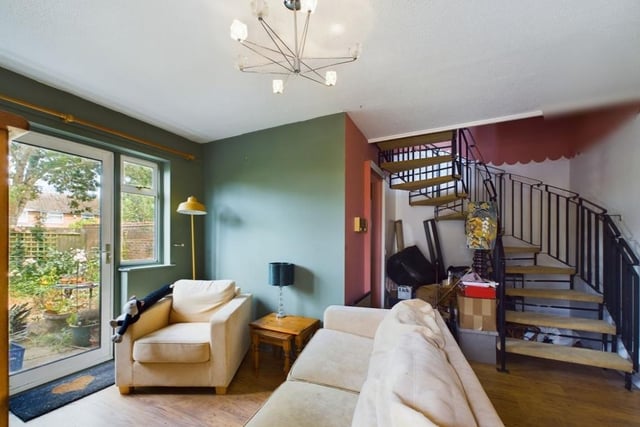 The lounge with a door out to the garden and a spiral staircase to the first floor