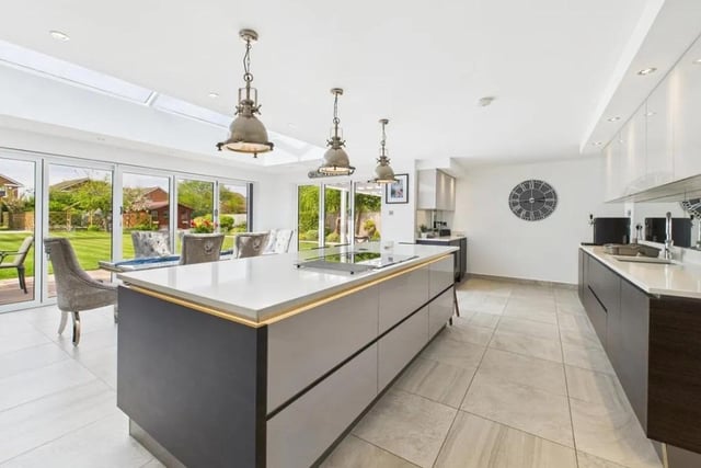 George David describes the kitchen as "beautifully designed with sleek cabinetry and premium worktops". The estate agent adds that it comes with a " a large kitchen island and a full range of integrated appliances".