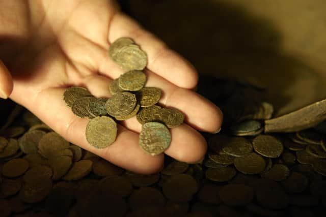 A British Museum worker examines part of a coin hoard