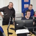 Presenters gather round the studio during a live broadcast