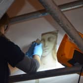 Conservator working to reveal wall paintings at Stowe House.
