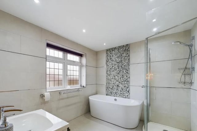 The family bathroom is fully tiled and comprises a low level wc, hand wash basin unit, walk in shower, bathtub with mixer tap, radiator and a frosted window.