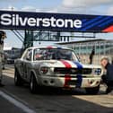A member of the pit crew checks the tyre pressure of a 1965 Ford Mustang during the HSCC Thundersports qualification stage of the Silverstone Festival. Photo: Getty Images.