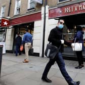 A man wearing PPE (personal protective equipment) passes customers queuing to enter a recently re-opened Pret-A-Manger shop which had originally closed-down due to the COVID-19 pandemic in London (Photo: TOLGA AKMEN/AFP via Getty Images)