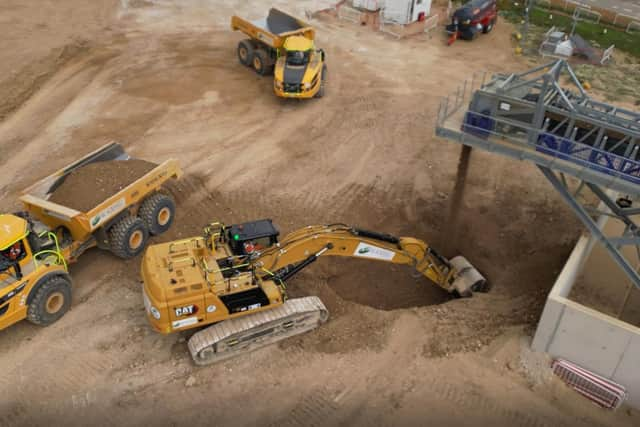 Excavators and tipper trucks at work shifting material delivered by the Wendover Conveyor