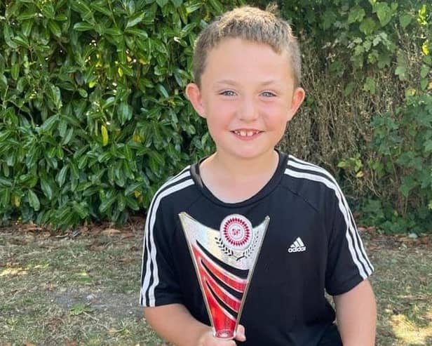 Smiling Alfred with his football trophy