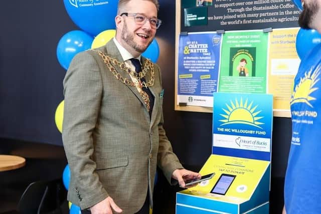 The town mayor testing out the new contactless donation box