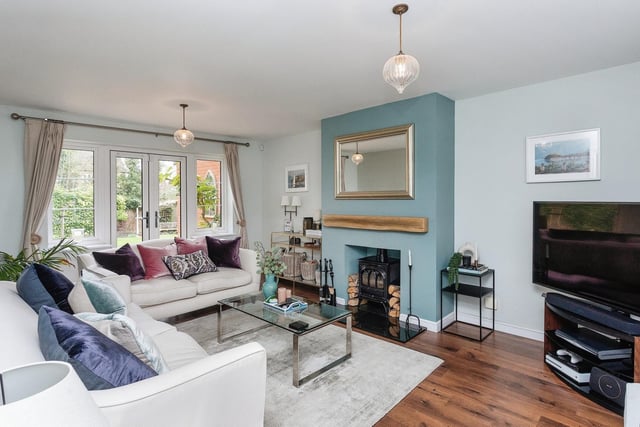 The sitting room features French doors leading to the garden, wood effect flooring and feature fireplace.