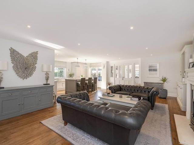 The property includes a dual-aspect sitting room with a feature fireplace and double doors