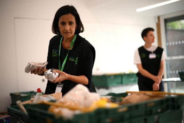 A member of staff sorts through food items inside a foodbank