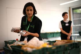 A member of staff sorts through food items inside a foodbank
