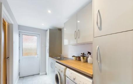 The utilities room contains a washing machine and dryer, plus plenty of cabinet space.