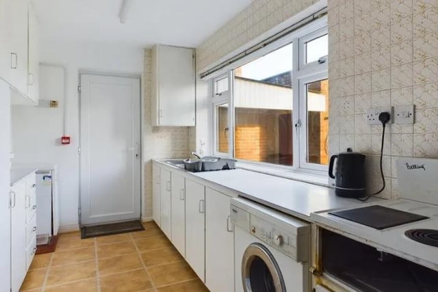 the kitchen consists of a range of base and wall mounted units with worktops, inset sink bowl unit, space for fridge/freezer, washing machine and freestanding cooker. Large window to the rear aspect, tiled flooring, under stairs cupboard and door to the garage.