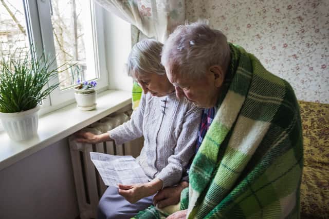 Couple read a bill by the radiator.