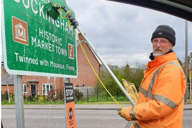 Greenspaces Team member Jerry cleaning street signs