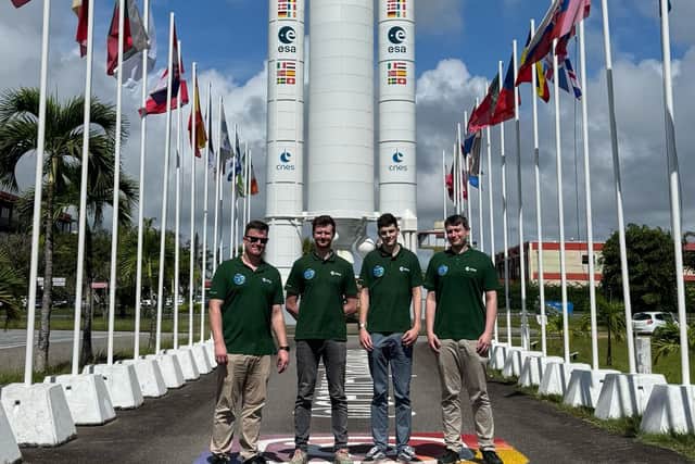 The European Astrotech team at the Biomass climate satellite launch site, Kourou: From left Jonathan Heirons, Dale Lockett, Oliver Graham and Ben Paran-Rutterford. They are pictured in front of a model of the Ariane 5 rocket, flanked by international flags.