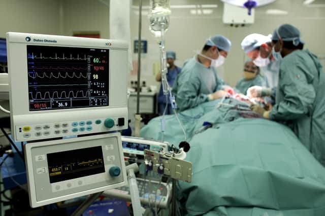 Surgeon carry out an operation. Photo credit: Andrew Parsons/PA.