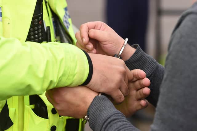 An individual being handcuffed. Photo from Joe Giddens/PA Images