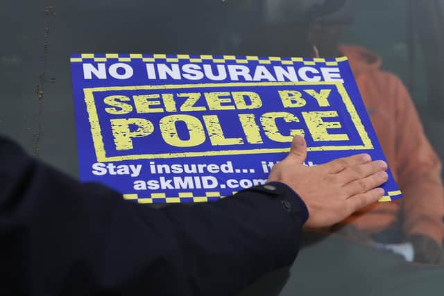 A sticker is placed on the windscreen of an uninsured car after it is seized by police. Photo by Joe Giddens/ PA Images