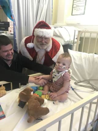 Father Christmas visits a young patient at Stoke Mandeville Hospital's children's ward - Alfie