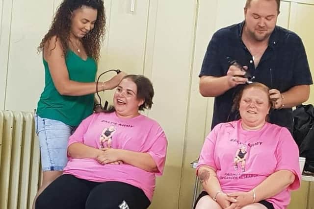 Laura Towse (right) and Jessica King having their heads shaved by stylists Graeme Elder and Emma Sonon