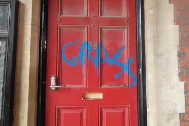 Photo taken this morning (Friday) showing graffiti sprayed on to a door opposite the statue