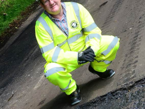 Cllr Mark Shaw by a section of recently repaired road