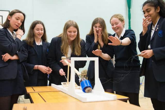 Members of the Aylesbury High School team giggle as they watch their design during testing