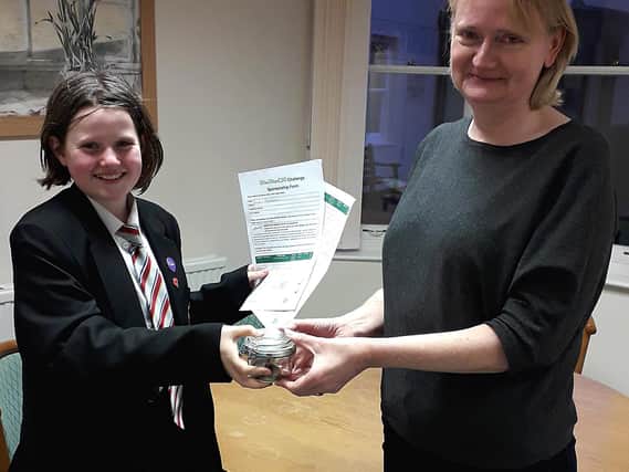 Evie Shanahan (left) presents the money raised to Jo Turner, CEO of the Florence Nightingale Hospice