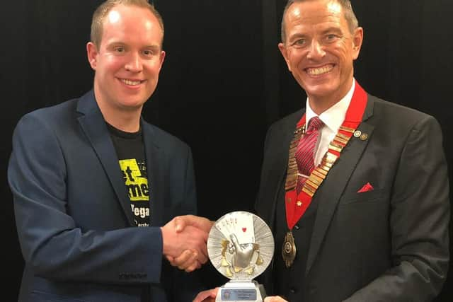 Simon Jones (left) receives the Home Counties close-up magic championship title