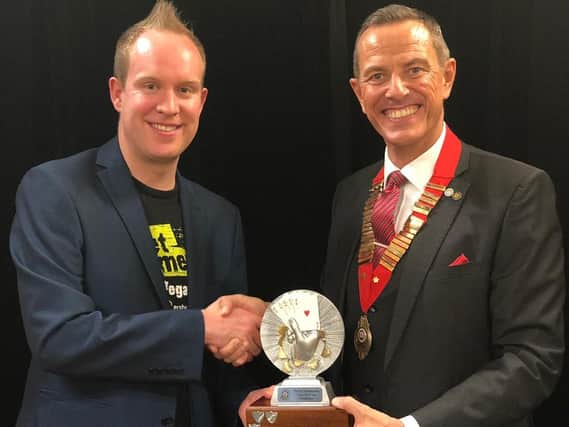 Simon Jones (left) receives the Home Counties close-up magic championship title