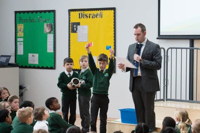 Green Ridge Primary Academy headteacher Aaron Wanford alongside pupils who are holding items that will be buried in the time capsule
