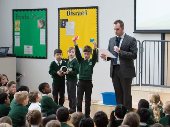 Green Ridge Primary Academy headteacher Aaron Wanford alongside pupils who are holding items that will be buried in the time capsule