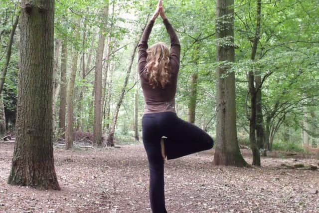 Instructor Simone Stribling demonstrates the backwards tree pose - a position used in woodland yoga
