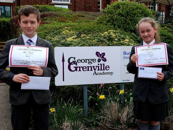 Ben Joyce and Chloe Pool outside George Grenville Academy with their thank you certificates from the Florence Nightingale Hospice
