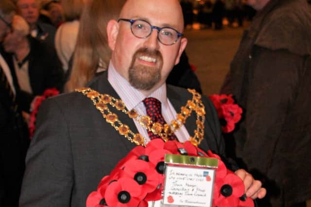 Mark Willis commemorating the fallen with a poppy wreath