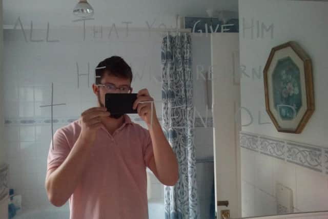 Ben Field taking pictures of the messages he wrote on Ann Moore-Martin's mirror